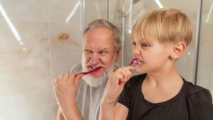 father son brushing teeth